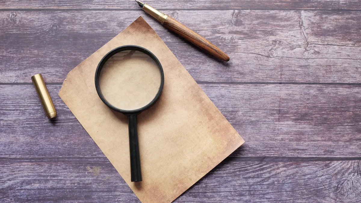 magnifying glass on paper beside a pencil